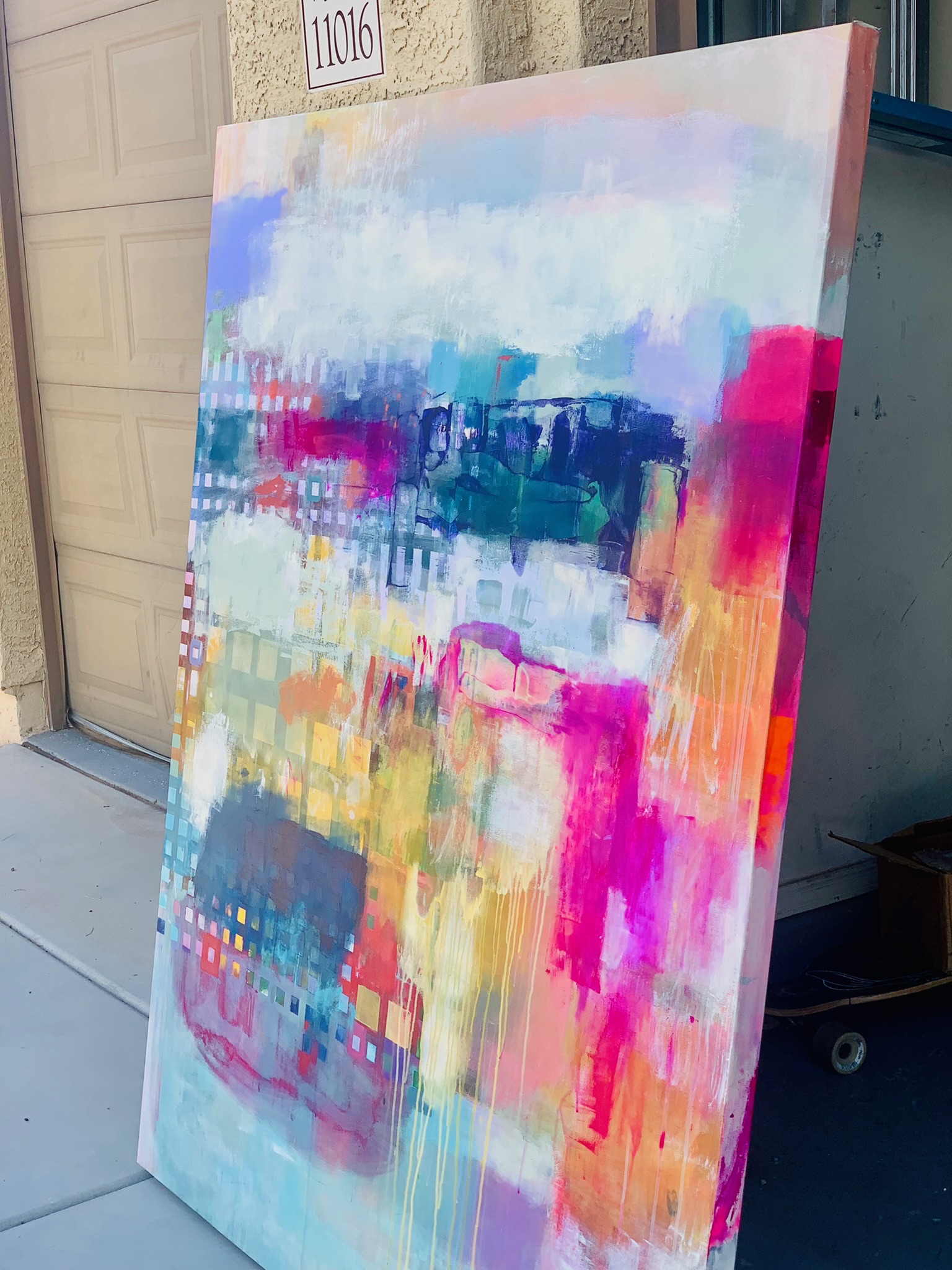 Large colorful abstract painting leaning in a studio doorway